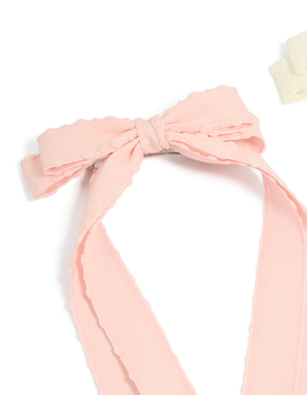 Featuring a 2-pack of fabric bow clips with scalloped edges in solid light pink and ivory detail view
