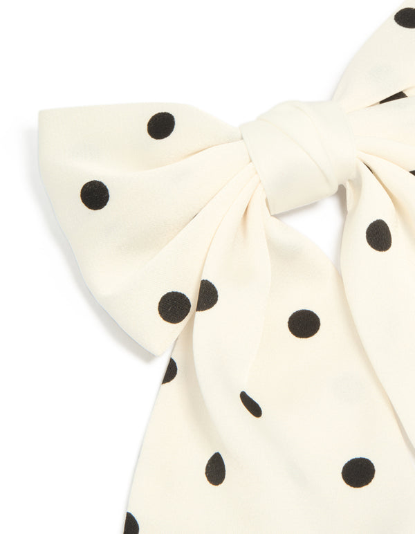 Crafted with white and black polka dot fabric bow hair clip side view