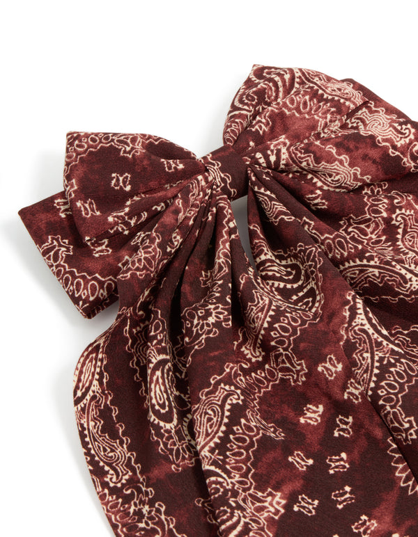 Elegant bow hair clip with paisley print in maroon, brown featuring statement design side view
