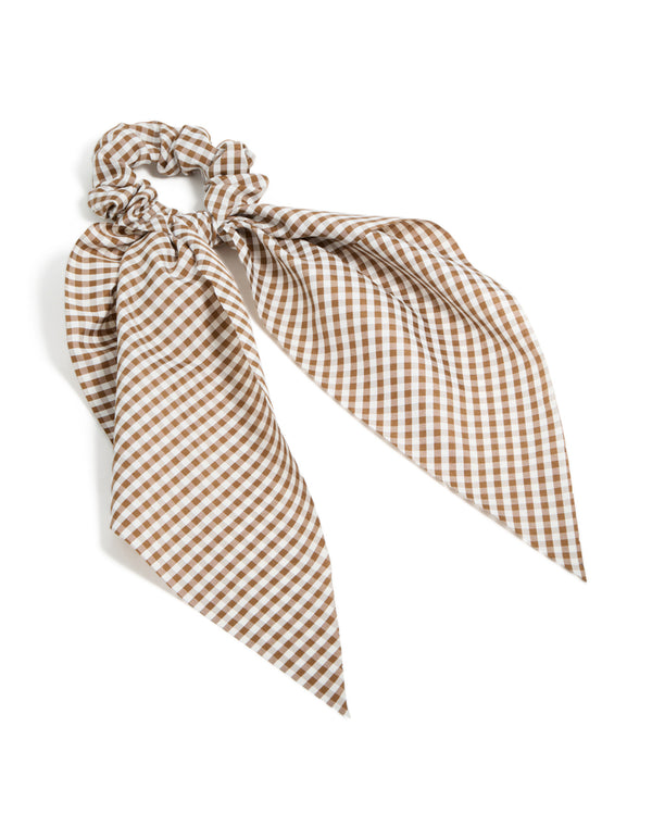 Showcasing a checkered fabric scrunchie scarf in saddle brown and white front view