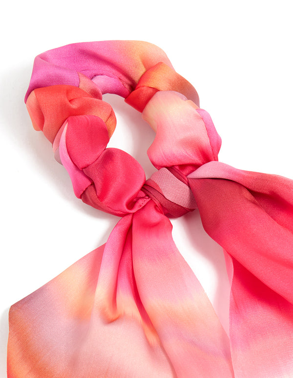 Showcasing a tie-dye long strap scarf scrunchie in statement hot pink, coral, and peachpuff shades detail view