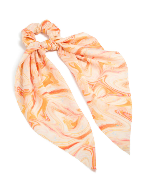 Featuring an abstract print in peachpuff, darkorange, this orange marbled fabric scarf scrunchie adds a statement touch front view
