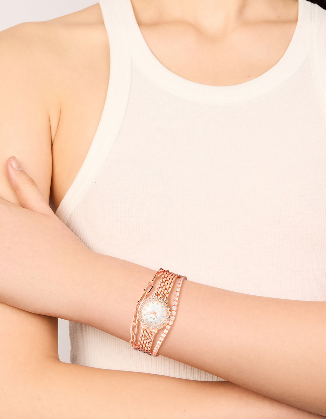 Designed with rose gold plated round diamante watch and bracelets pack featuring clear stone dial, formal women's analog timepiece with link band strap on wrist view