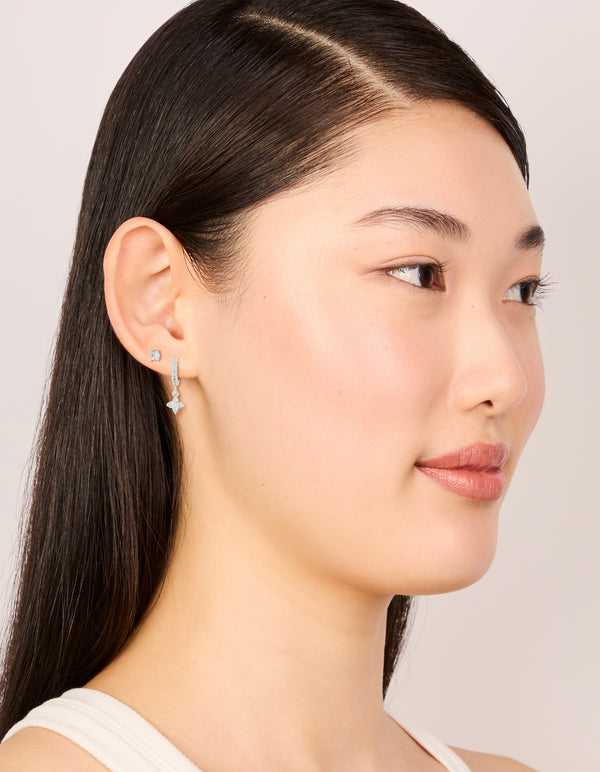 Crafted from silver plated cubic zirconia studs and flower huggie earrings in a 2-pack on model view