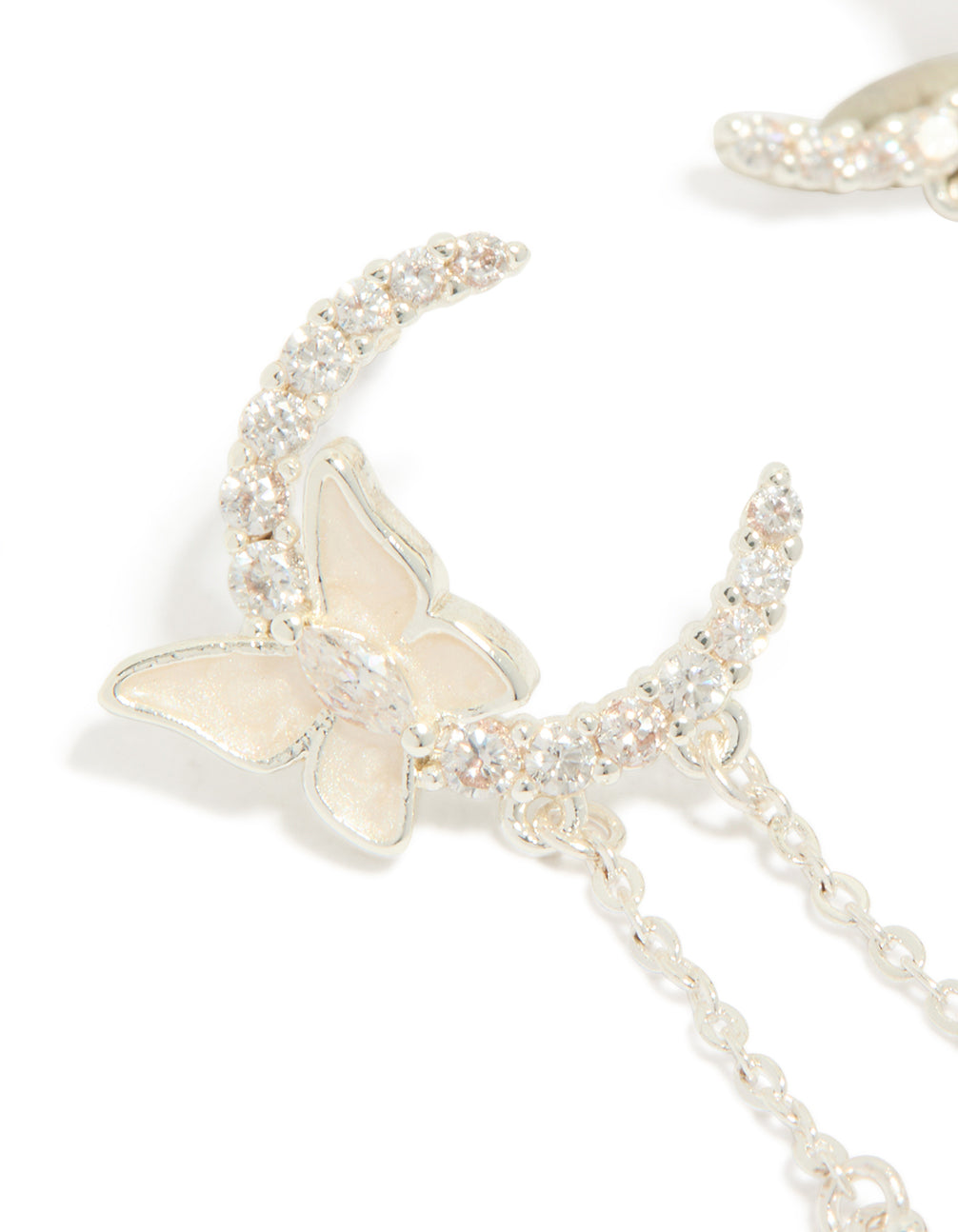 Detailed view of silver plated cubic zirconia moon and butterfly drop earrings with celestial charm pearl accents close up view