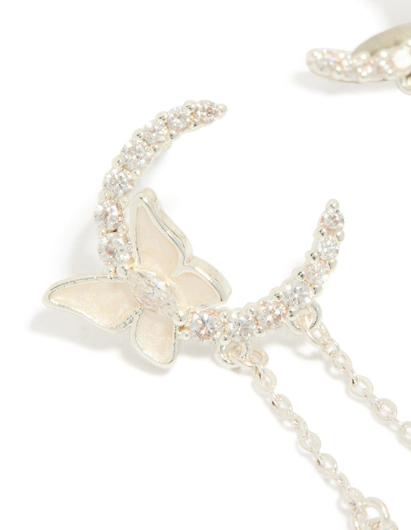 Detailed view of silver plated cubic zirconia moon and butterfly drop earrings with celestial charm pearl accents close up view