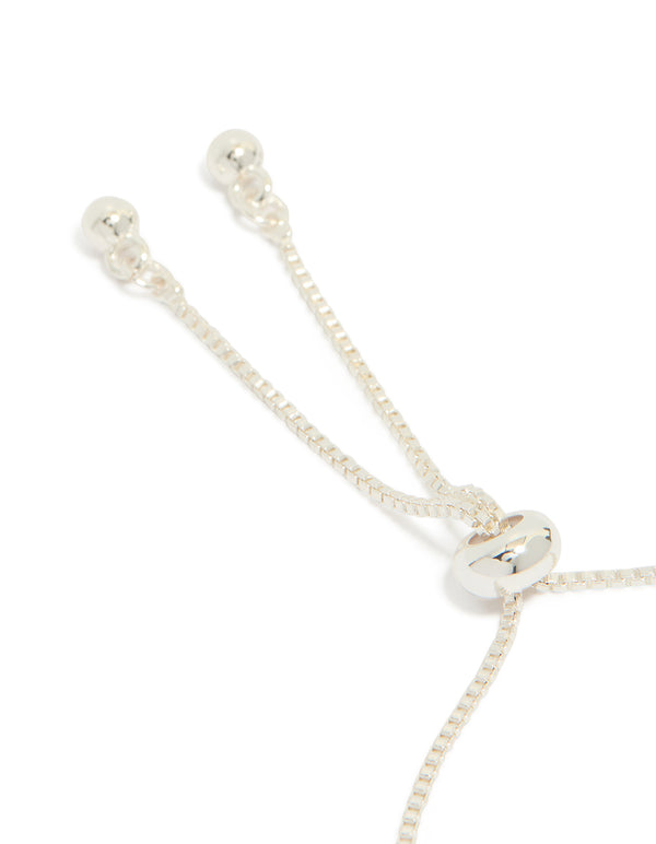 Highlighting a silver plated toggle bracelet with smooth butterfly charms and cubic zirconia inlay closure detail view
