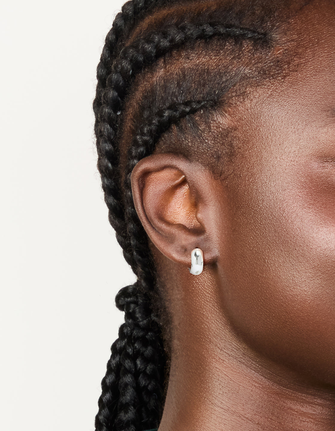 Featuring chunky waterproof silver plated stainless steel huggie earrings on ear view