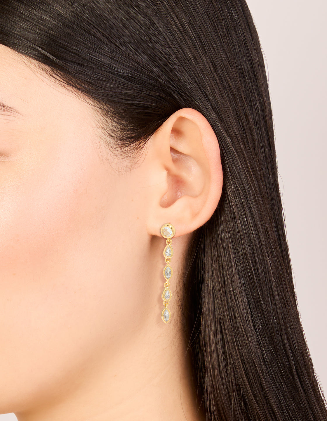 Elegant gold plated cubic zirconia mixed shape long drop earrings in statement style on ear view
