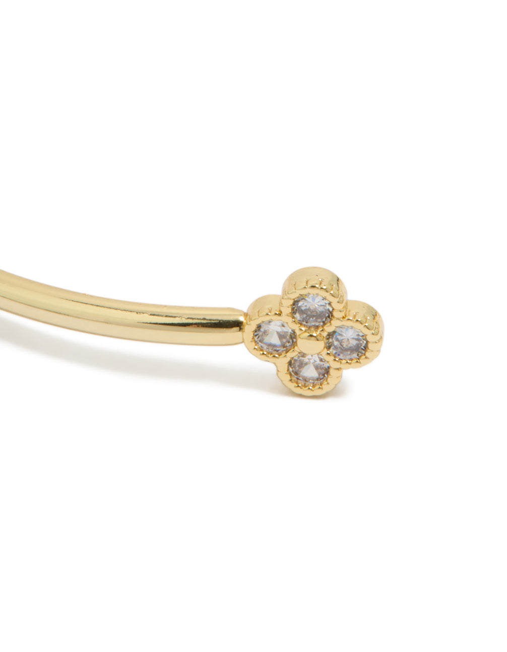 Highlighting a floral statement wrist cuff in gold plated metal with cubic zirconia close up view