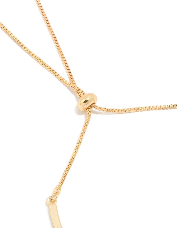 Highlighting a gold plated bangle with celestial moon and heart charm toggle closure detail view