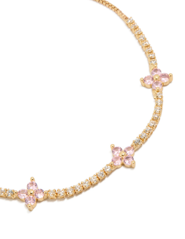 Crafted from gold plated metal, this toggle bracelet with clear and pink cubic zirconia flowers close up view