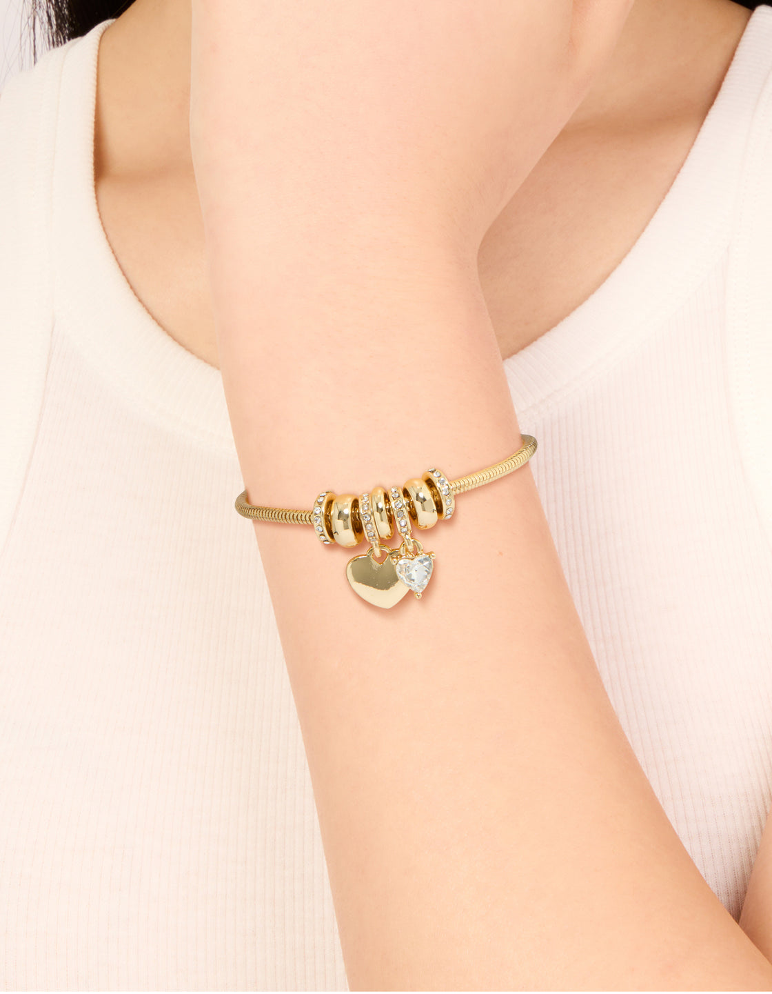Featuring a gold plated cubic zirconia chunky heart charm toggle bracelet design on wrist view