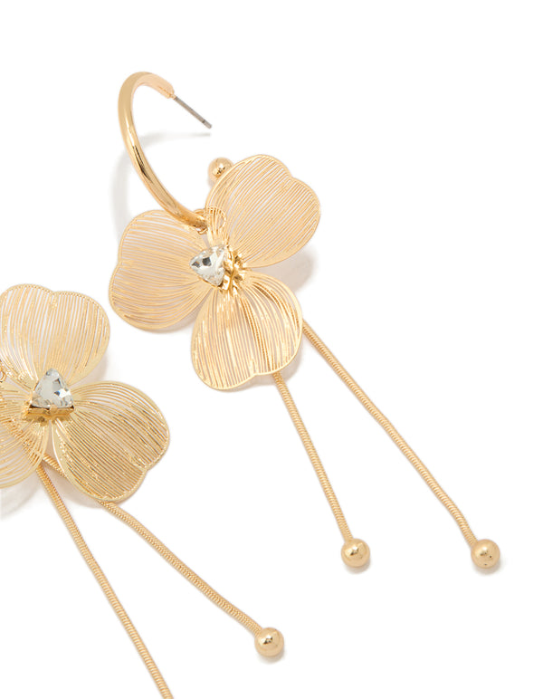 Featuring statement style laser cut flower drop earrings in gold close up view