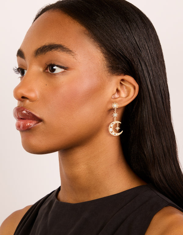 Styled gold pearl celestial drop earrings featuring charm elements on model view