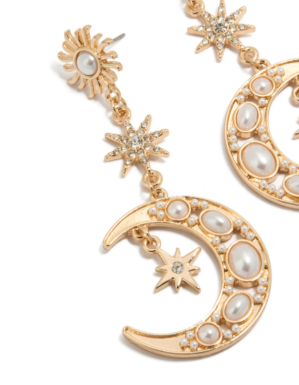 Detailed look at gold pearl celestial drop earrings with charm embellishments close up view