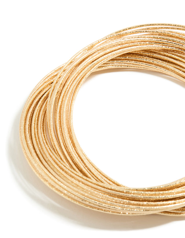 This multi crossover bangle features worn gold finish in close up view