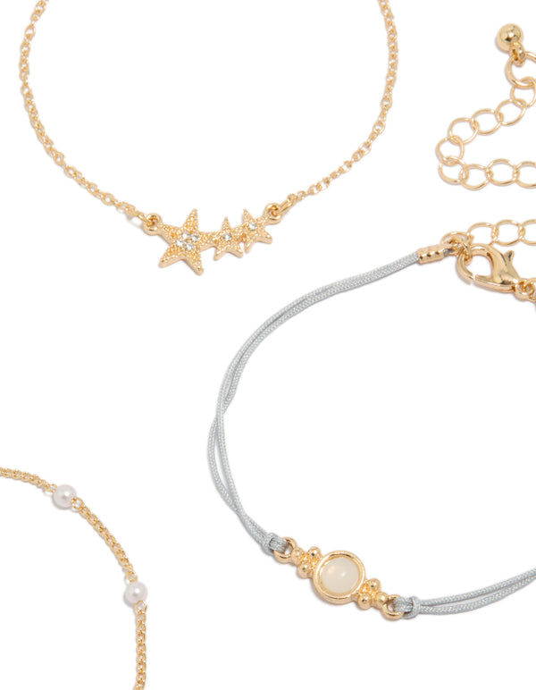 Designed with gold pearl and light blue cord bracelets in a 4-pack featuring celestial star and moon elements closure detail view