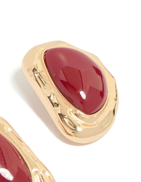 Crafted with organic textured design featuring dark red stone in gold finish statement stud earrings post detail view