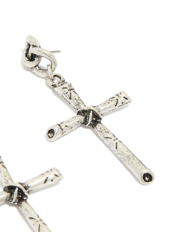 Highlighting antique silver edgy textured cross drop earrings with chunky styling post detail view