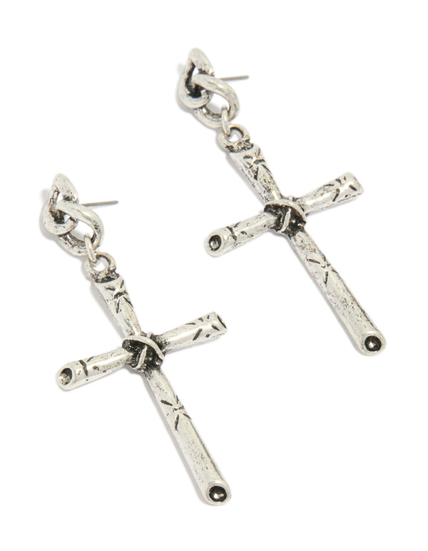 Showcasing antique silver edgy textured cross drop earrings with chunky styling front view