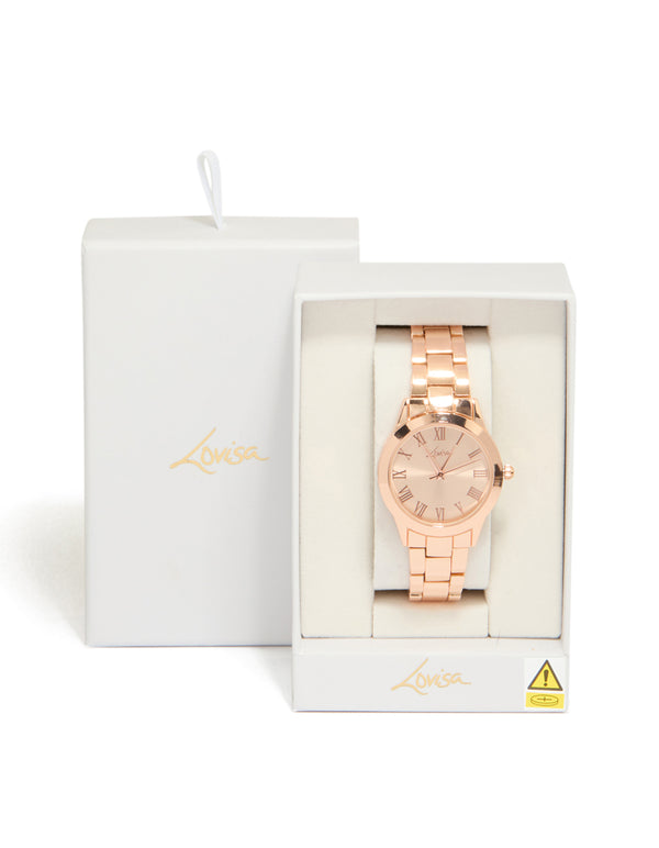 Presenting a rose gold classic round roman numeral watch with numbers, pink dial, women's link band, formal occasion, analog timepiece case detail view