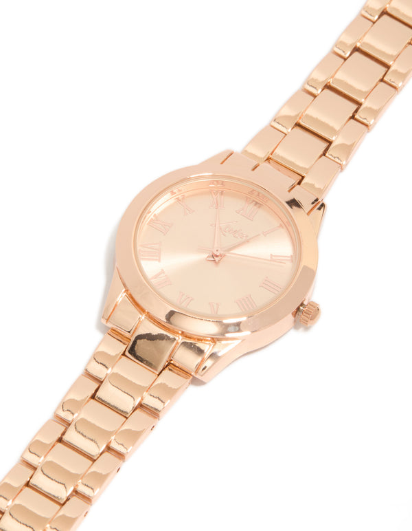 Showcasing a rose gold classic round roman numeral watch with numbers on pink dial, women's link band, formal occasion, analog timepiece watch face detail view