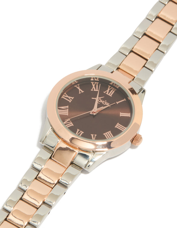 Elegant mixed metal watch with brown roman numeral dial, round shape, formal occasion, women's analog timepiece, link band in multi-color, gold and silver tones watch face detail view