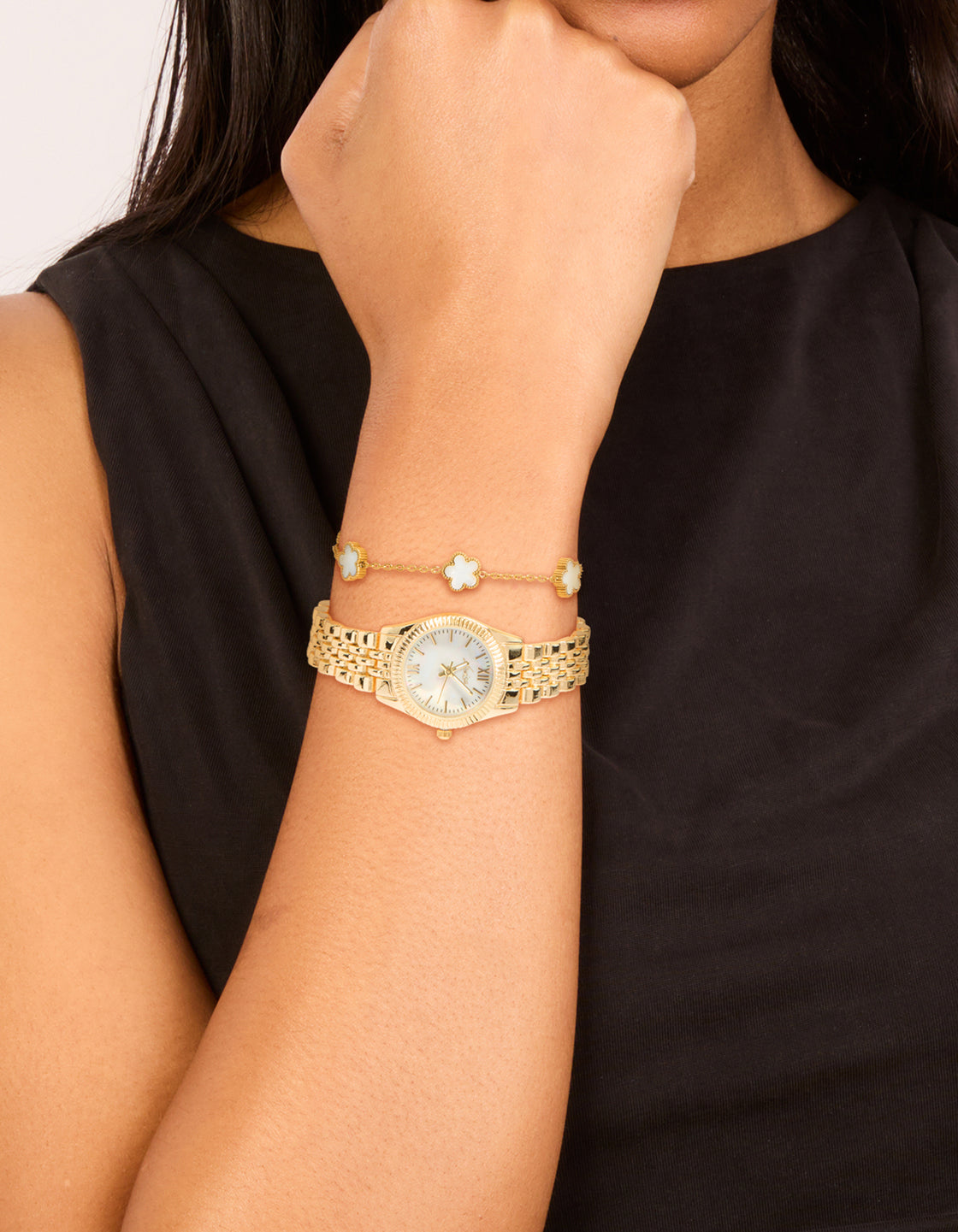 Elegant gold watch and flower bracelet set featuring floral pattern, white roman numeral dial, round shape, women's casual analog timepiece, link band strap on wrist view