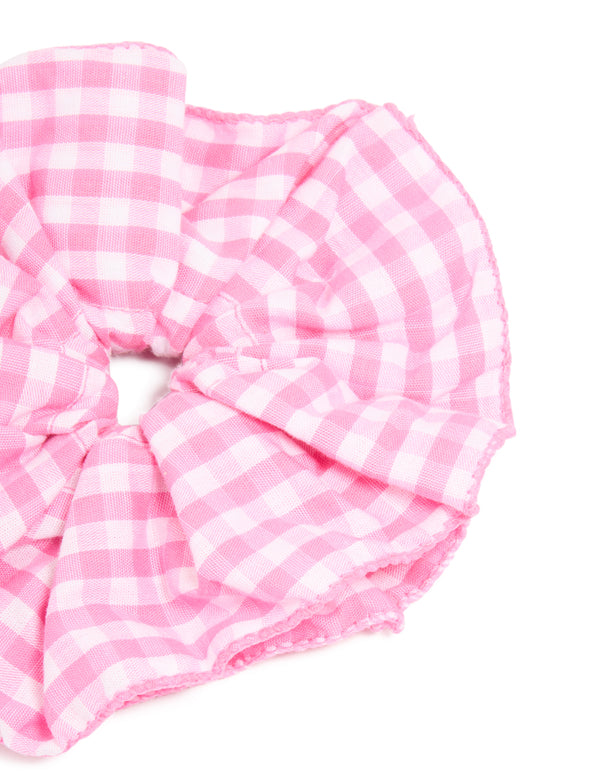 Designed with checkered fabric, this ruffled scrunchie in pink and white side view