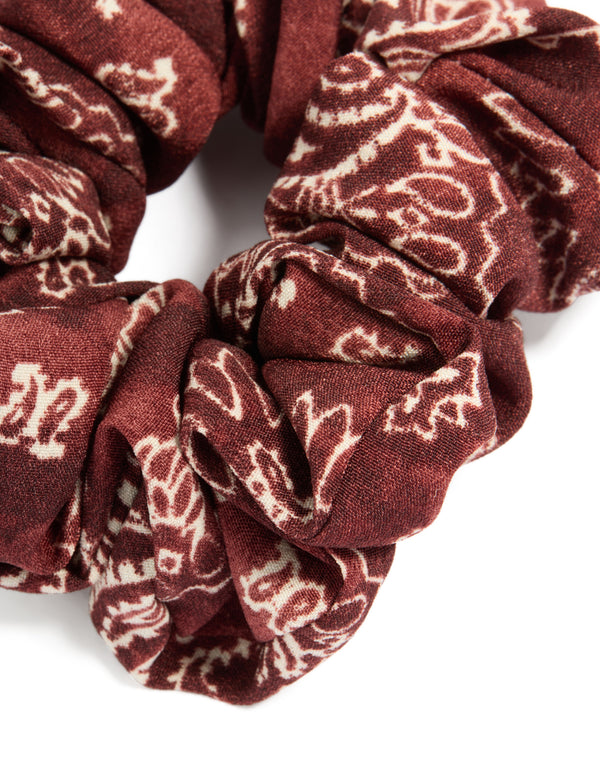 This statement fabric scrunchie showcases paisley design in maroon and beige tones detail view