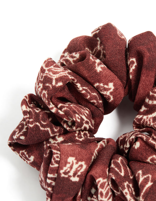 Crafted statement fabric scrunchie features paisley design in maroon beige tones side view