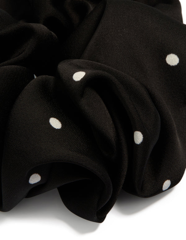 Crafted from polka dot patterned fabric, this statement scrunchie features micro dots in black and white detail view