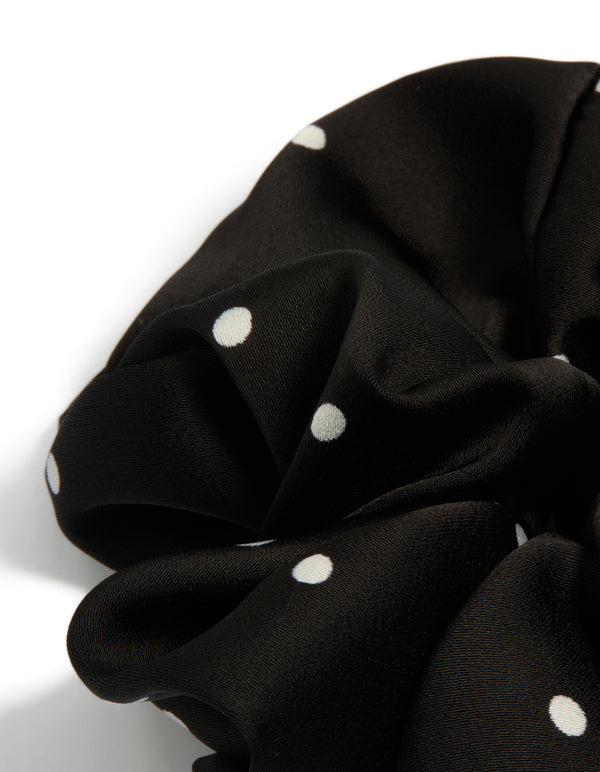 Designed with micro polka dot pattern, a statement scrunchie in black and white fabric side view
