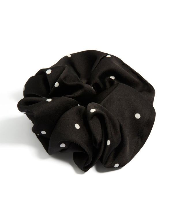 Showcasing a statement scrunchie in micro polka dot pattern with black and white fabric front view