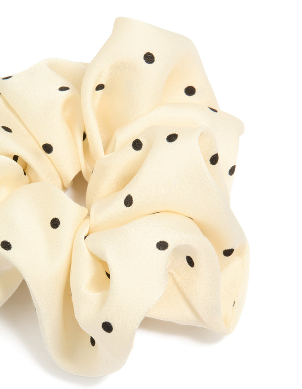 Featuring polka dot pattern in cornsilk and black statement fabric scrunchie side view
