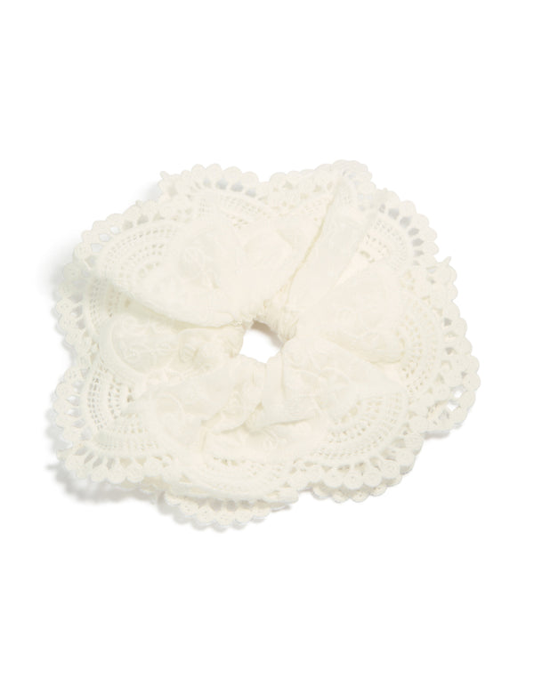 Showcasing a white fabric broderie edge statement scrunchie with floral embroidered detailing in solid front view