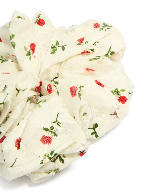 Crafted from fabric, this statement scrunchie showcases floral printed roses with leaf design in ivory, red and olive hues side view