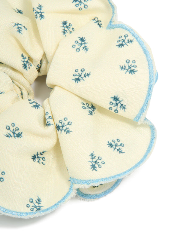 Featuring a ruffled scrunchie with floral print in ivory, sky blue and teal side view