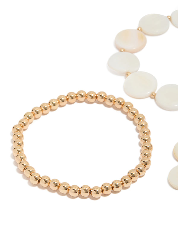 Showcasing gold beaded and genuine shell discs bracelets 4-pack with ocean-inspired design in ivory and beige close up view