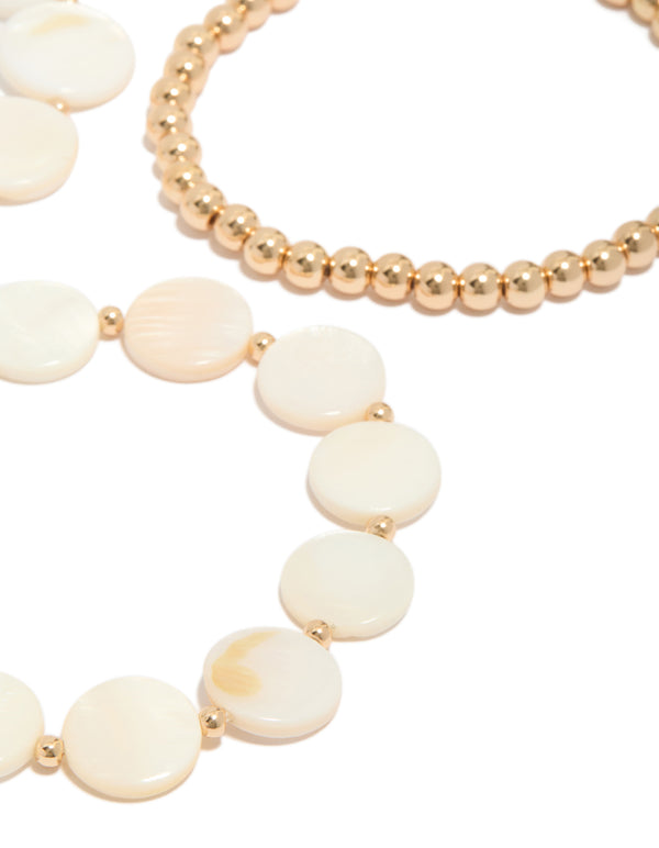 Crafted with gold beads and genuine shell discs in ivory and beige tones, these 4-pack bracelets highlight ocean-inspired design detail view