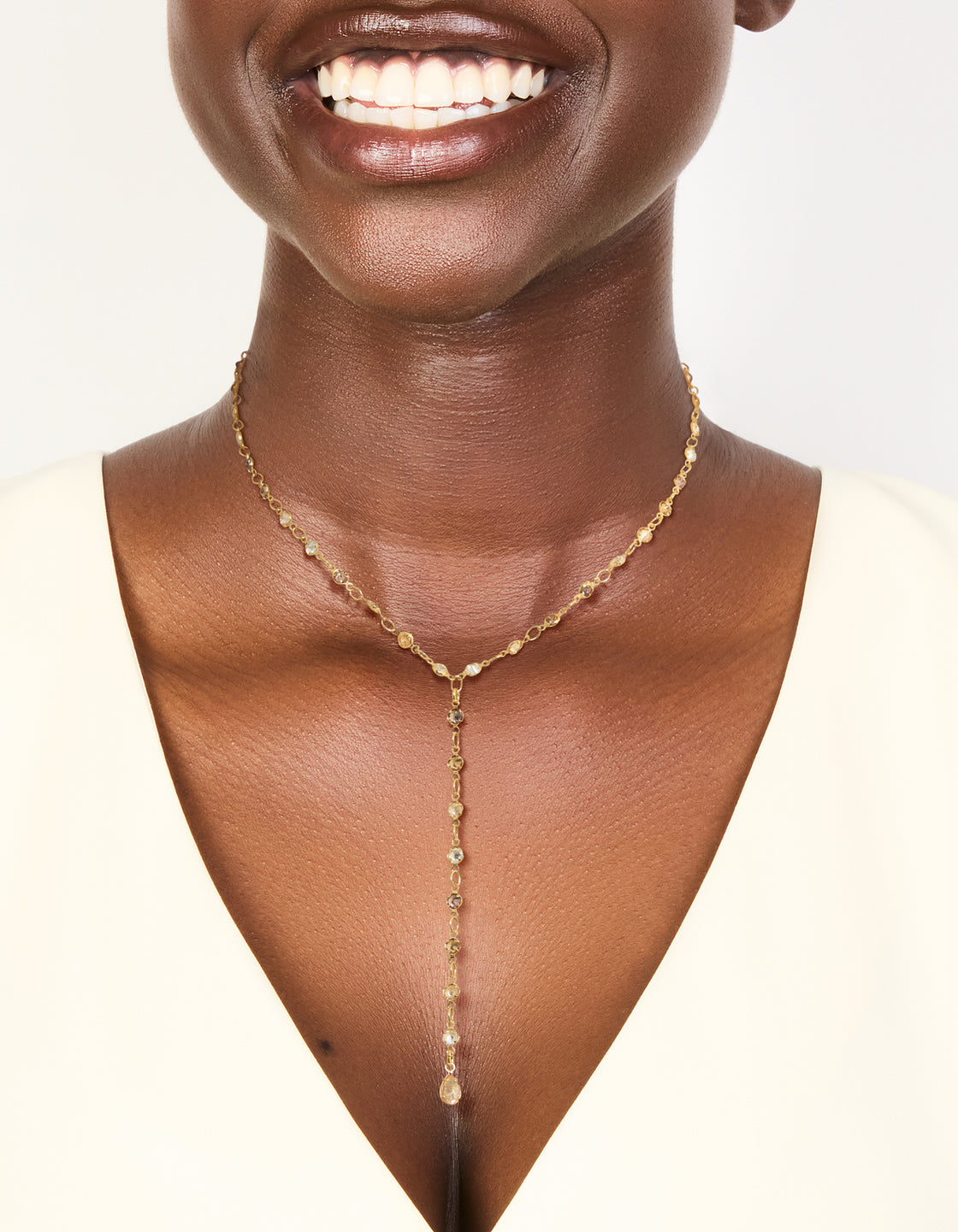 Showcasing a gold plated multicoloured cubic zirconia circle detailed charms Y-necklace with dainty pendant on neck view