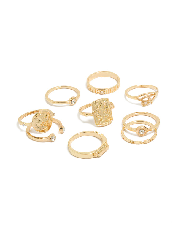 Showcasing dainty gold rings featuring numbers and disc details with clear diamante accents in a 9-pack front view