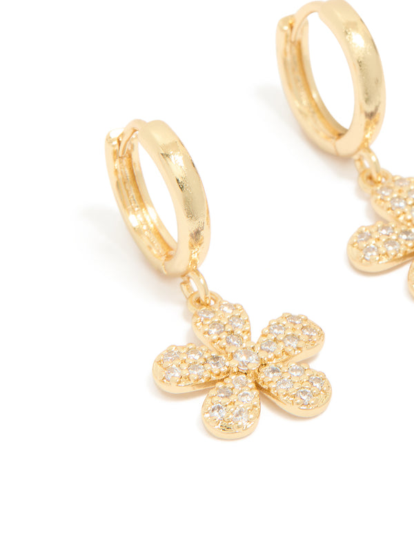 Showcasing dainty floral huggie earrings in gold plated finish featuring pave set cubic zirconia detailing close up view