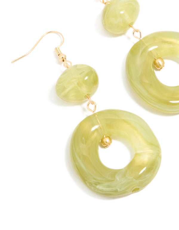 Featuring gold green acrylic circle drop earrings close up view