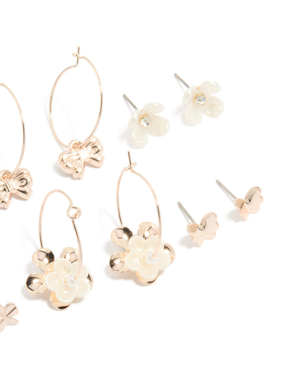 Showcasing rose gold pearlised flower and bee earrings 8-pack with bow, butterfly, heart and pearl ivory accents, stud and huggie closures on ear view