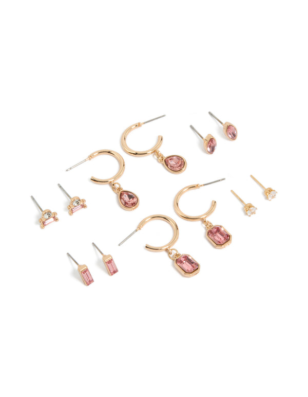 Showcasing a 7-pack of gold pink diamante stud and hoop earrings featuring baguette and oval stone cuts front view