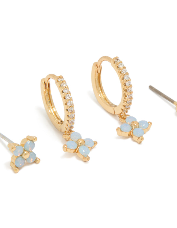 Featuring gold plated blue flower stud and huggie earrings in a 3-pack with balls in powder blue accents close up view