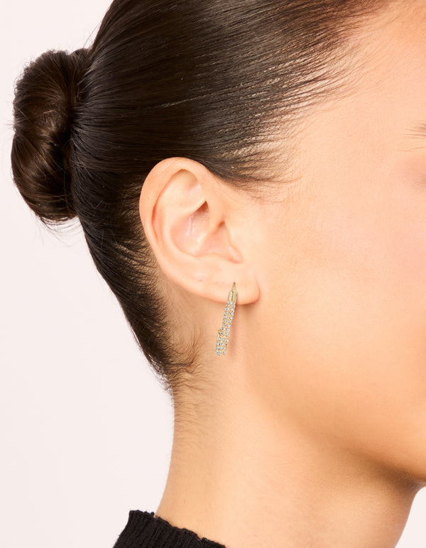 Featuring gold diamante safety pin hoop earrings with sparkling stones in an on ear view