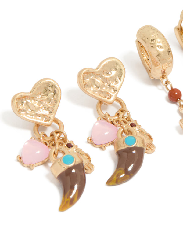 Crafted from worn gold, this statement earrings 3-pack with beads, charm, cross, heart, and huggie, stud closure close up view